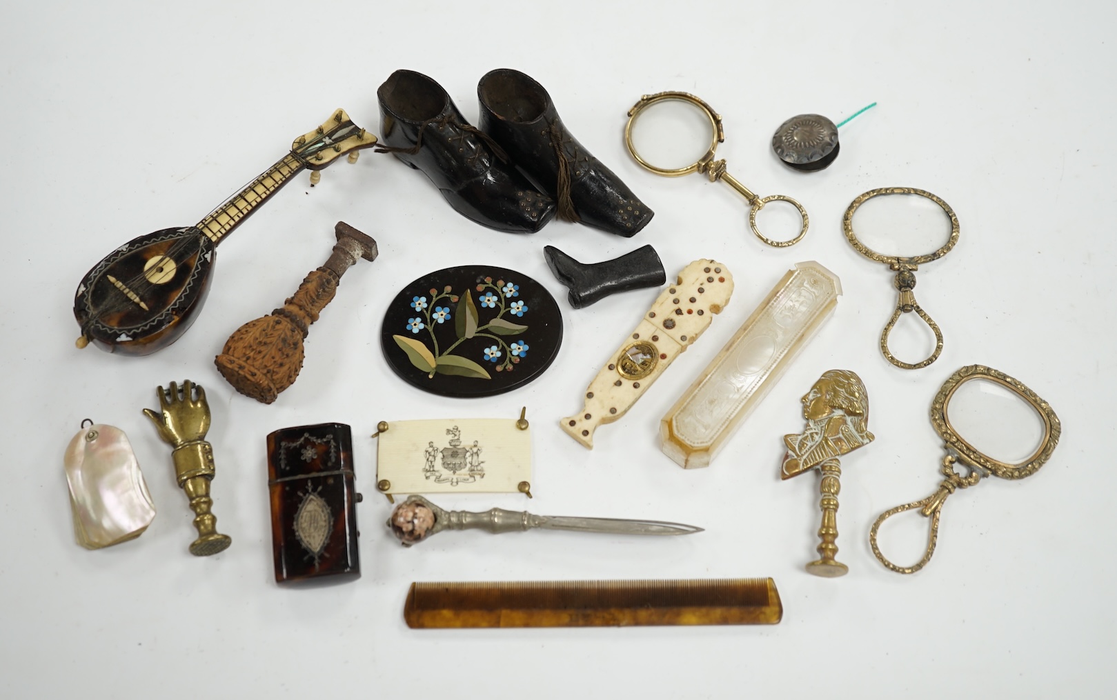 Miscellaneous objects of vertu including a pair of carved wood boots, an inlaid tortoiseshell needle case, a carved mother of pearl box and a pietra dura oval floral panel, largest 12.5cm in length. Condition - mostly fa